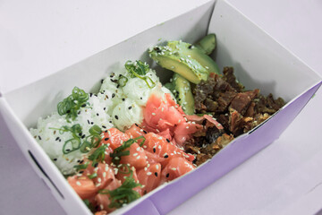 Preparing sushi with Raw salmon steak, rice and fresh avocados
