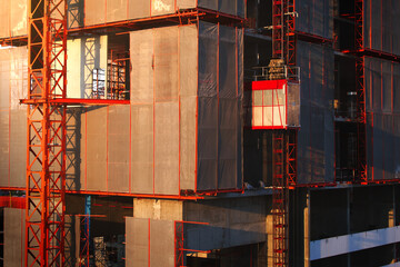 Elevator used for worker and moving materials at, Construction site, Passenger lift system outdoor, Development land and residential building in city.