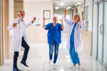 Professional medical doctor team with stethoscope in uniform discussing and dancing with happy patient woman with cancer cover head with headscarf of chemotherapy cancer in hospital.health care