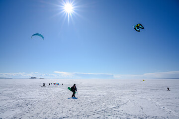 Snow kiting on a frozen lake under the bright spring sun