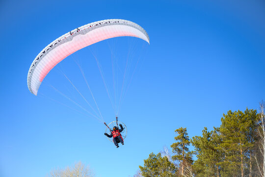 Motor paraplane flying over the forest