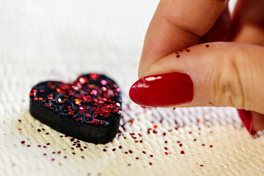 concept of healing broken heart. black heart with red glitter