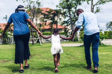 Fototapeta premium Portrait of enjoy happy love black family african american father and mother holding little african girl hand in moments good time in summer park at home