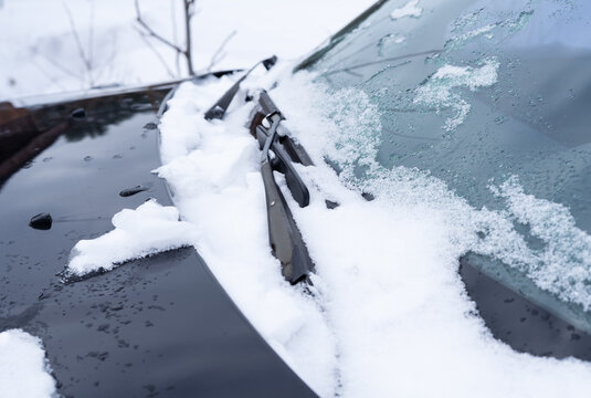 Car windshield wipers frozen in the snow
