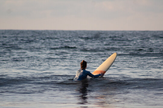 Mujer joven aprendiendo a surfear en playa de Sayulita, M&eacute;xico.