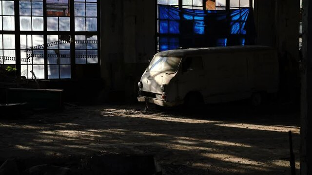 Old van in an abandoned factory with stained glass windows. Glare of the sun from the stained-glass windows of the old factory - 4K