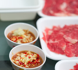 bowl of sauce dip with slice meat for asian shabu