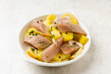 Salted herring with spices and chopped boiled potatoes. Selective focus. Shallow depth of field.