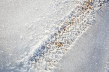 Tire tracks through frozen snow and ice
