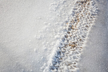 Tire tracks through frozen snow and ice