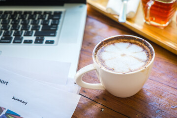 Coffee mugs on work desks and laptops