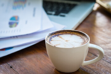 Coffee mugs on work desks and laptops