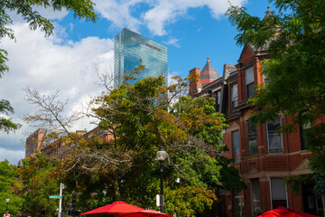Historic commercial buildings on Newbury Street with John Hancock Tower at the background in Back Bay, Boston, Massachusetts MA, USA. 