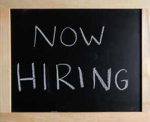 Fototapeta premium now hiring written on black chalkboard. white chalk