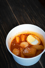 Stir-fried Rice Cake Tteok-bokki in a takeaway container. Korean food delivery.