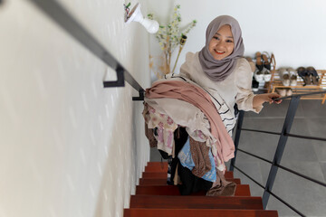 Cute malay woman doing routine housework by folding her laundry