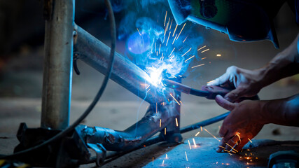 Welding of steel, sparking, not wearing gloves, light colored like fireworks.