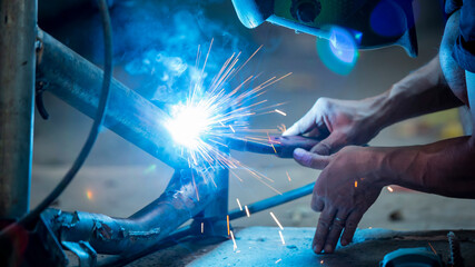 Welding of steel, sparking, not wearing gloves, light colored like fireworks.