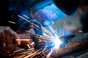 Welding of steel, sparking, not wearing gloves, light colored like fireworks.