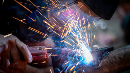 Welding of steel, sparking, not wearing gloves, light colored like fireworks.