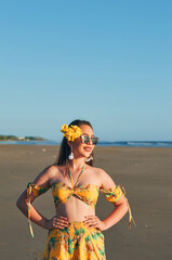 Portrait of a woman in a yellow summer outfit at the beach