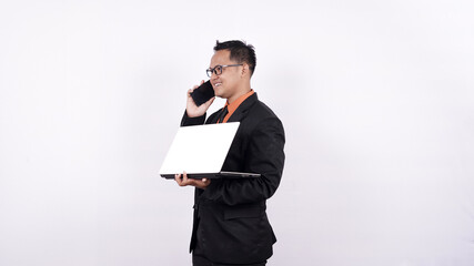 businessman holding a laptop computer while on the phone isolated white background