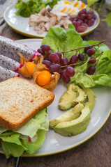 Dragon fruit, grape, whole wheat bread, boiled chicken breast and boiled egg, broccoli in a healthy vegetarian dish. 