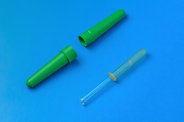 Medical pipette with case on blue background close-up