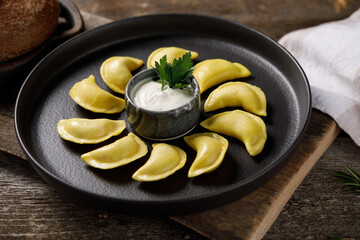 Appetizing traditional Russian dumplings made by hand with delicious filling. Still life on a wooden board. Close-up.