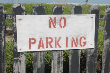 No parking sign on picket fence