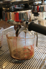 blur of coffee machine making steaming coffee.