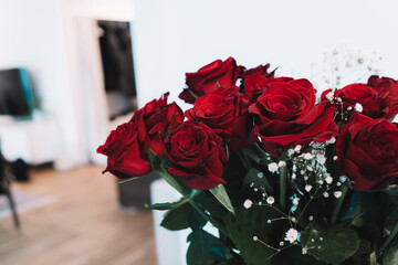 Red roses with white flowers in a vase - home decoration