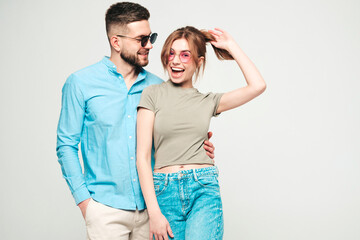 Smiling beautiful woman and her handsome boyfriend. Happy cheerful family having tender moments.Posing on grey background in studio.Pure models hugging in sunglasses.Embracing each other.Love concept