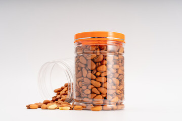 Pine nuts and scattered pine nuts in a transparent box on a pure white background