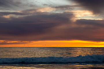 Fototapeta na wymiar View of a sunset over a sea.