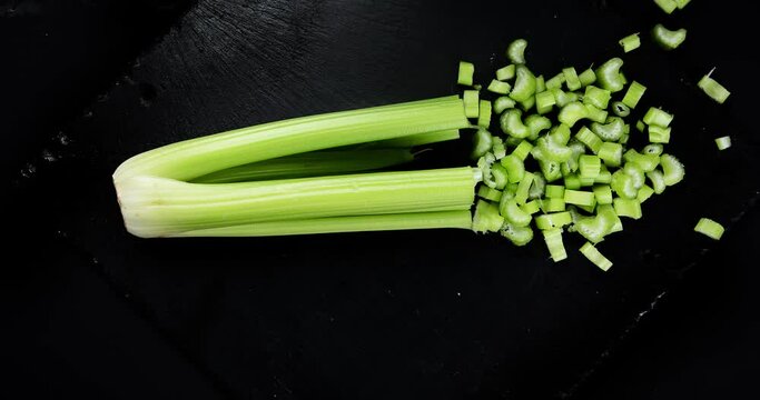 Cutting celery plant. Healthy and detox food concept.  Stop motion animation, 4K.