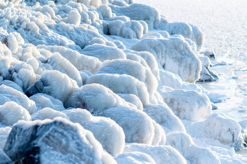 Stones near the sea, covered with ice and snow