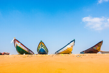 Fishing boats on land with clear blue sky background