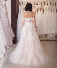 the bride chooses a wedding dress in the store