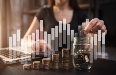 Business woman holding coins putting in glass with using  calculator to calculate concept saving money for finance accounting.