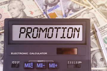 On the table are dollars and a calculator on the electronic board which says PROMOTION