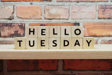 Hello Tuesday alphabet letter on shelves wooden background