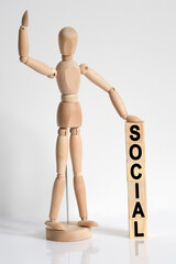 The wooden man raised his hand, and under his left hand he has cubes with the inscription - SOCIAL