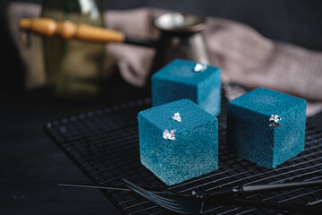 Blue cake filled with orange and tangerine in the shape of a cube. Rustic style.