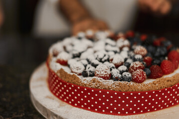 Homemade cheesecake with raspberry and blueberry decorated with icing sugar. Cake with fresh berries