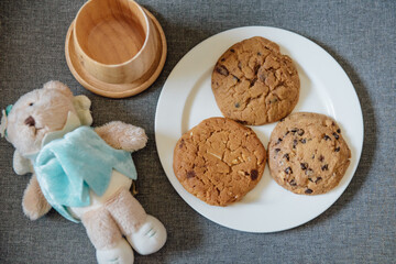 Traditional homemade Soft​ Cookies​ with dolls and wooden cup on table. View top.