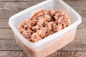 Raw minced meat with rice in a container for preparing meat balls or cutlets