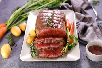 roasted beef sliced with sauce and potatoes