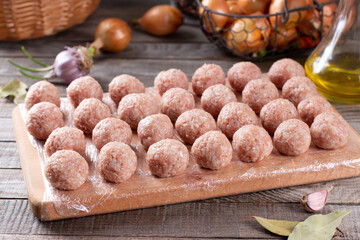 Semi-finished products, raw meatballs, meat patties on a cutting board on a table