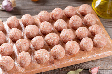 Semi-finished products, raw meatballs, meat patties on a cutting board on a table